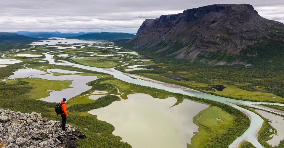 Man som blickar ut från berg över delta