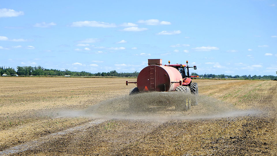 Traktor som sprider konstgödsel